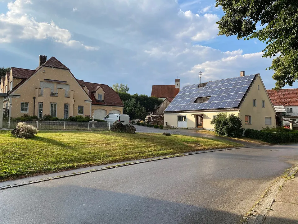 Einfamilienhaus mit Photovoltaikanlage auf dem Dach in einer Wohnstraße