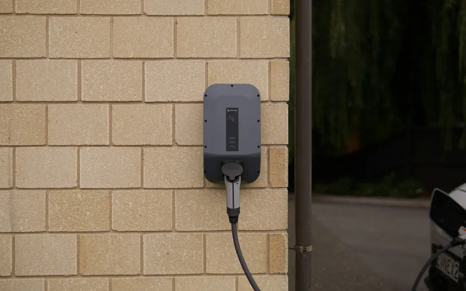 Wallbox an einer Ziegelwand neben der Garageneinfahrt
